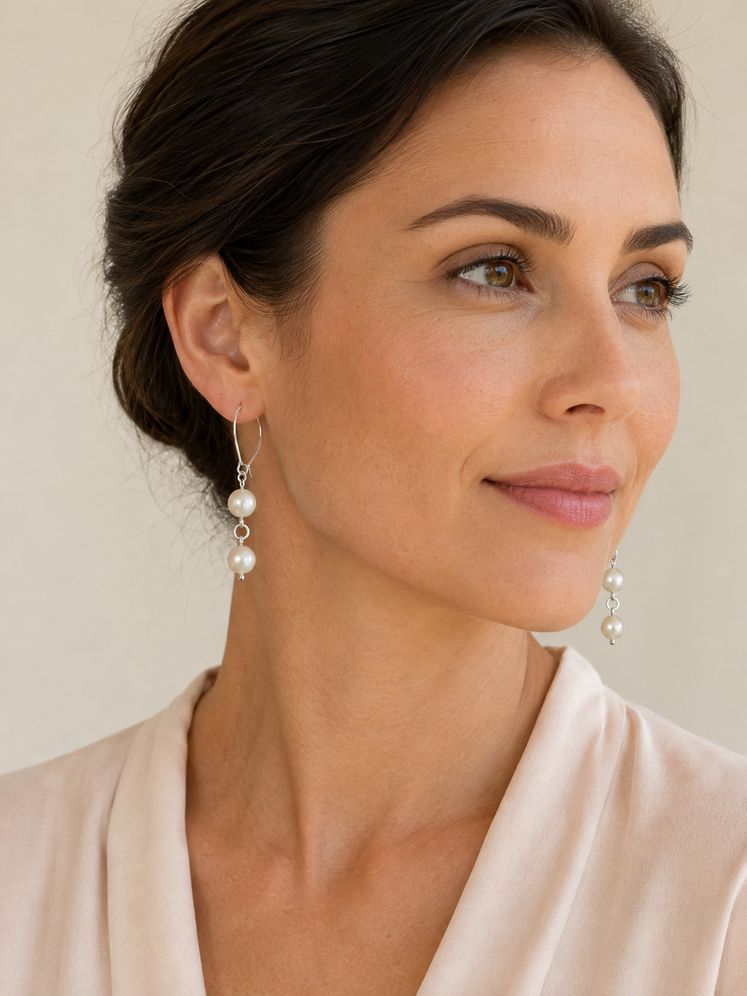 Model wearing handmade pearl drop earrings with sterling silver kidney hooks against a neutral background – FKJ-209E by Kalitheo