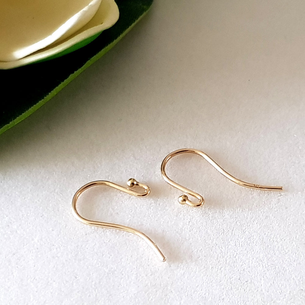 laying down on white table gold earring hooks
