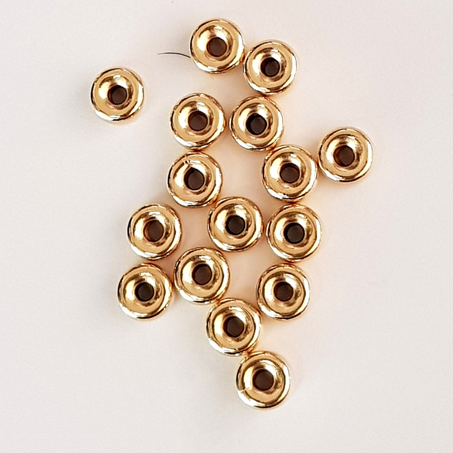 Gold beads on a light beige background