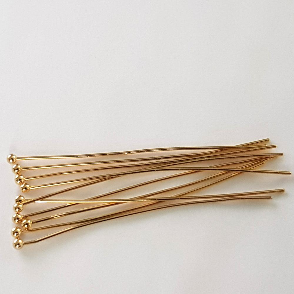 Gold headpins on a white background