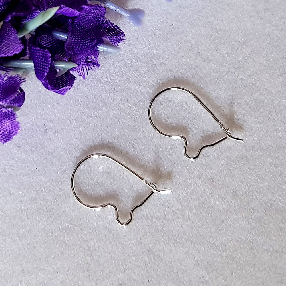 A pair of small kidney-shaped silver earring hooks with a polished and shiny finish on a white background.