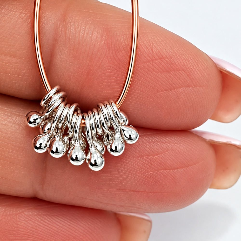 Handmade solid Argentium ball dangles clustered on a necklace design, creating a shimmering fringe