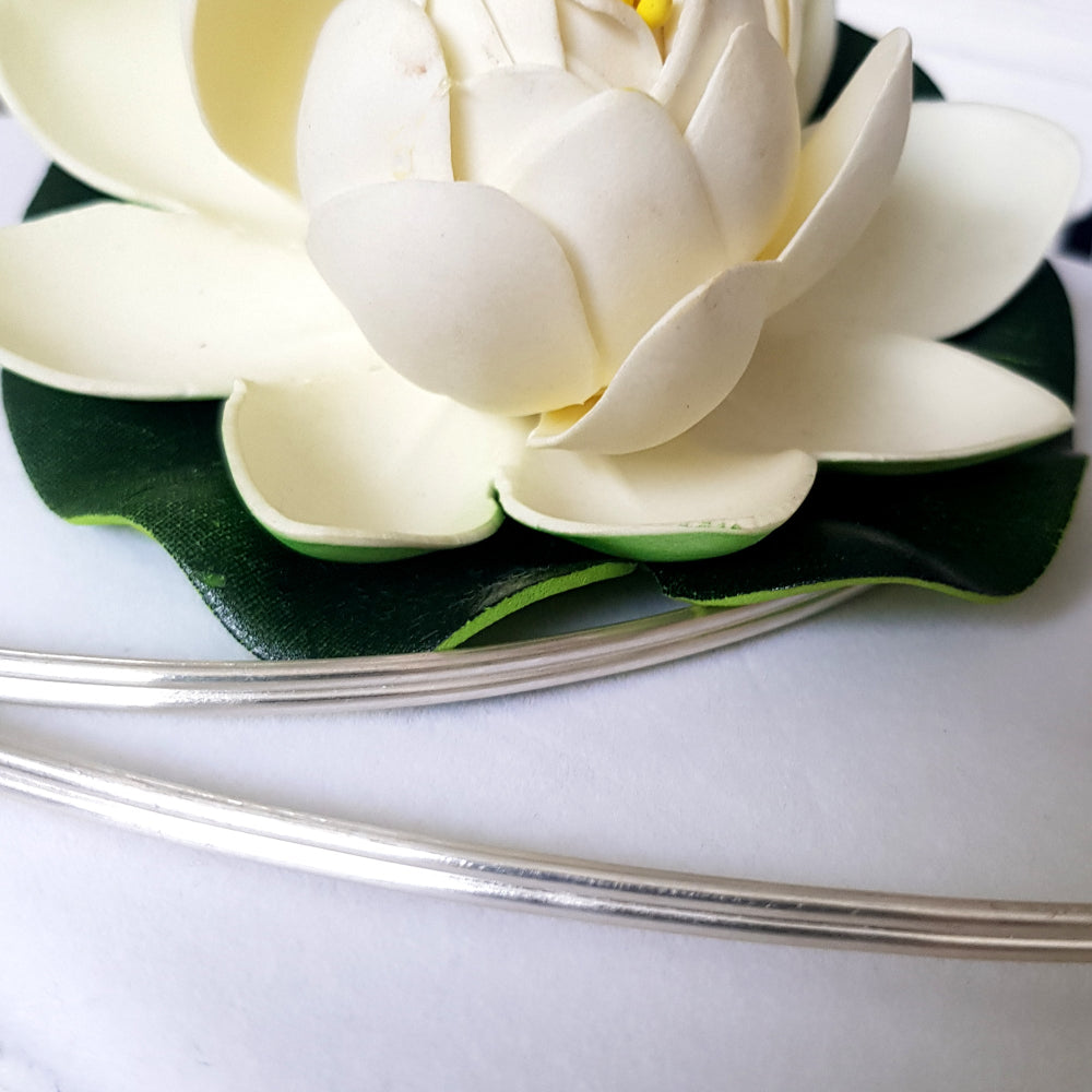 another close up double half round wire coiled around a white flower.