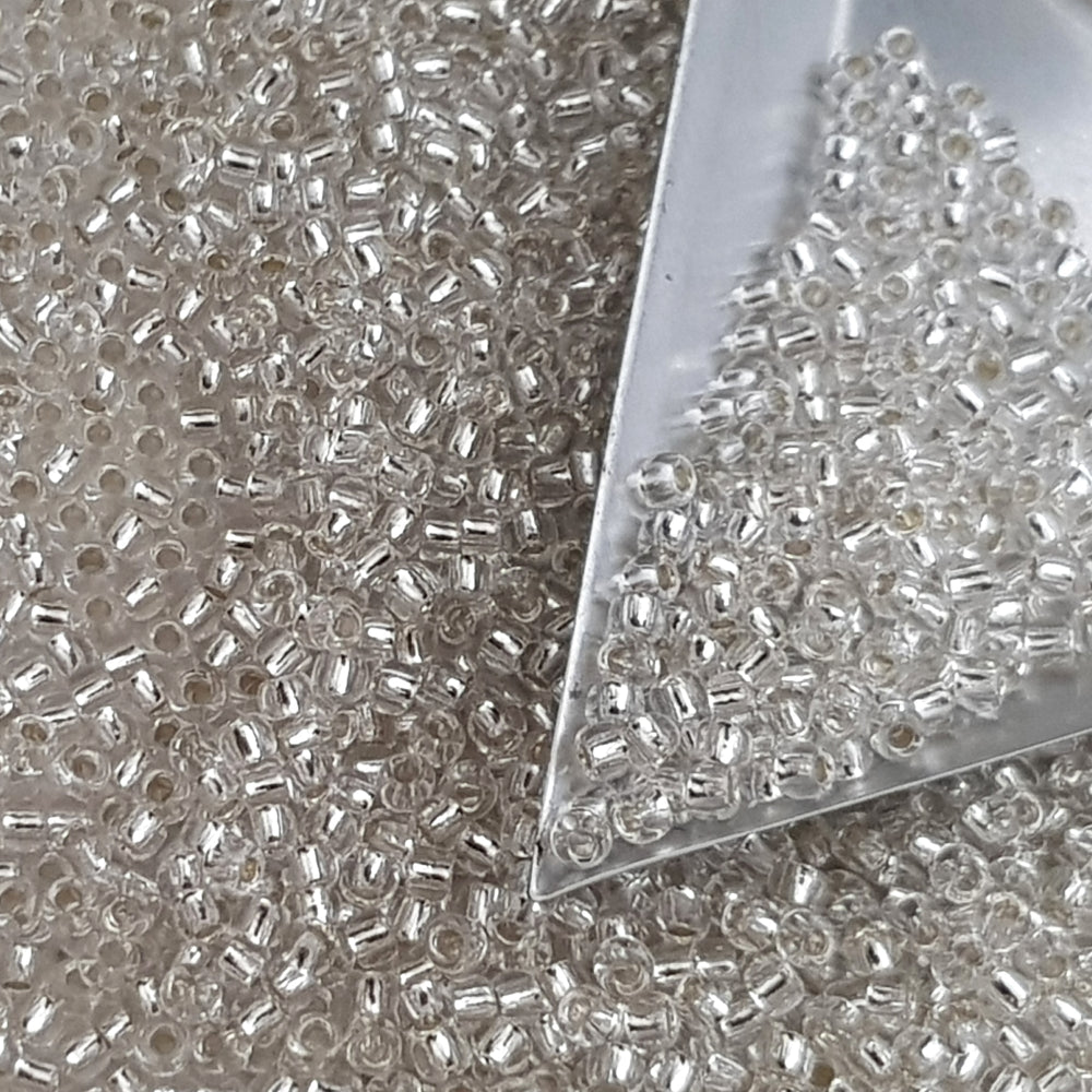 Toho 11/0 Crystal Silver-Lined TR-21 with a triangle scoop.