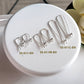 Set of silver earring hooks on a white round tray with labels.