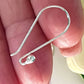 Silver earring on a person's finger