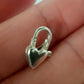 Silver heart-shaped clasp on a hand