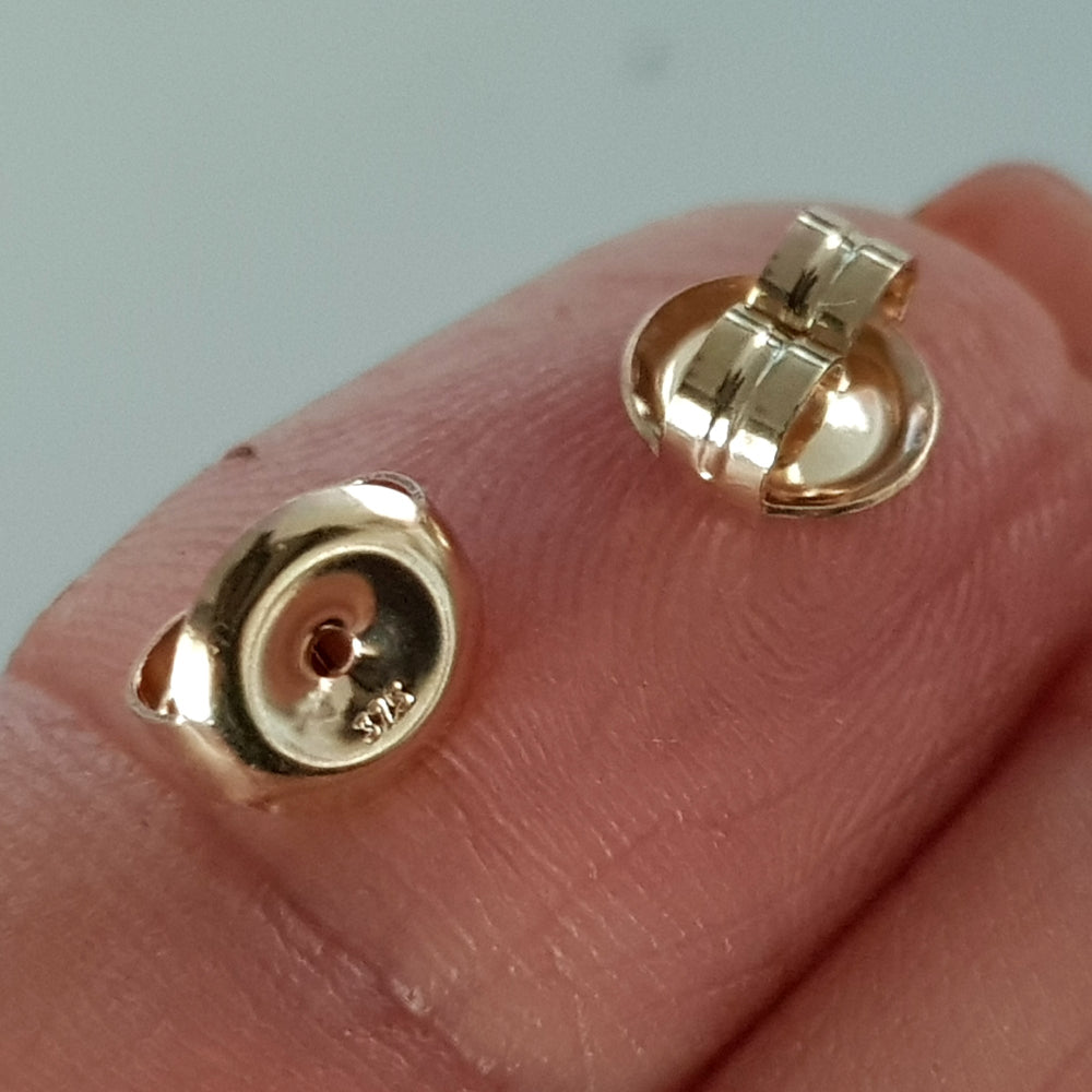 9ct yellow gold earring backs stamped 375 on a finger.
