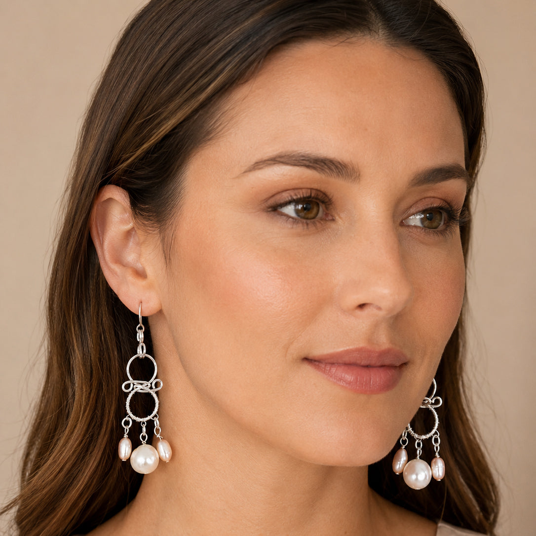 Model wearing handmade chandelier pearl earrings in sterling silver and Argentium with white and soft-pink freshwater pearls – FKJ-210E by Kalitheo