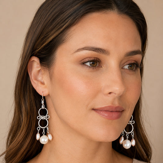 Model wearing handmade chandelier pearl earrings in sterling silver and Argentium with white and soft-pink freshwater pearls – FKJ-210E by Kalitheo