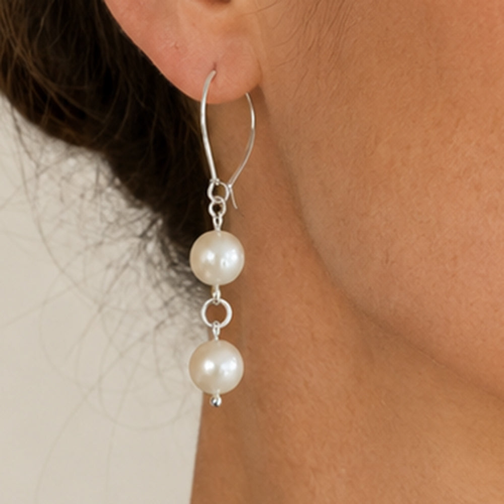 Close-up of model wearing handmade sterling silver kidney hook earring with two white freshwater pearls – FKJ-209E by Kalitheo