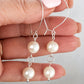 Pair of handmade sterling silver kidney hook earrings with two white freshwater pearls held in hand – FKJ-209E by Kalitheo