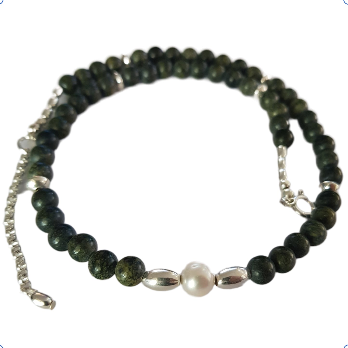 Necklace with green beads and a pearl on a white background
