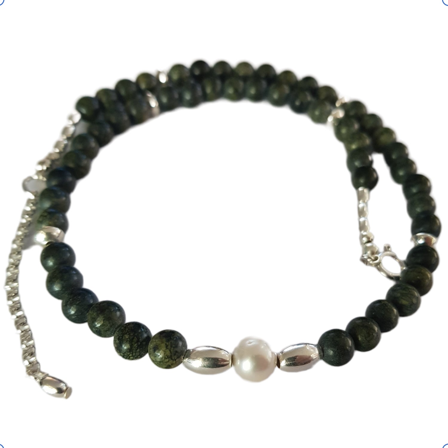 Necklace with green beads and a pearl on a white background