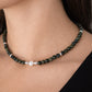 Necklace with green beads and a pearl on a person's neck