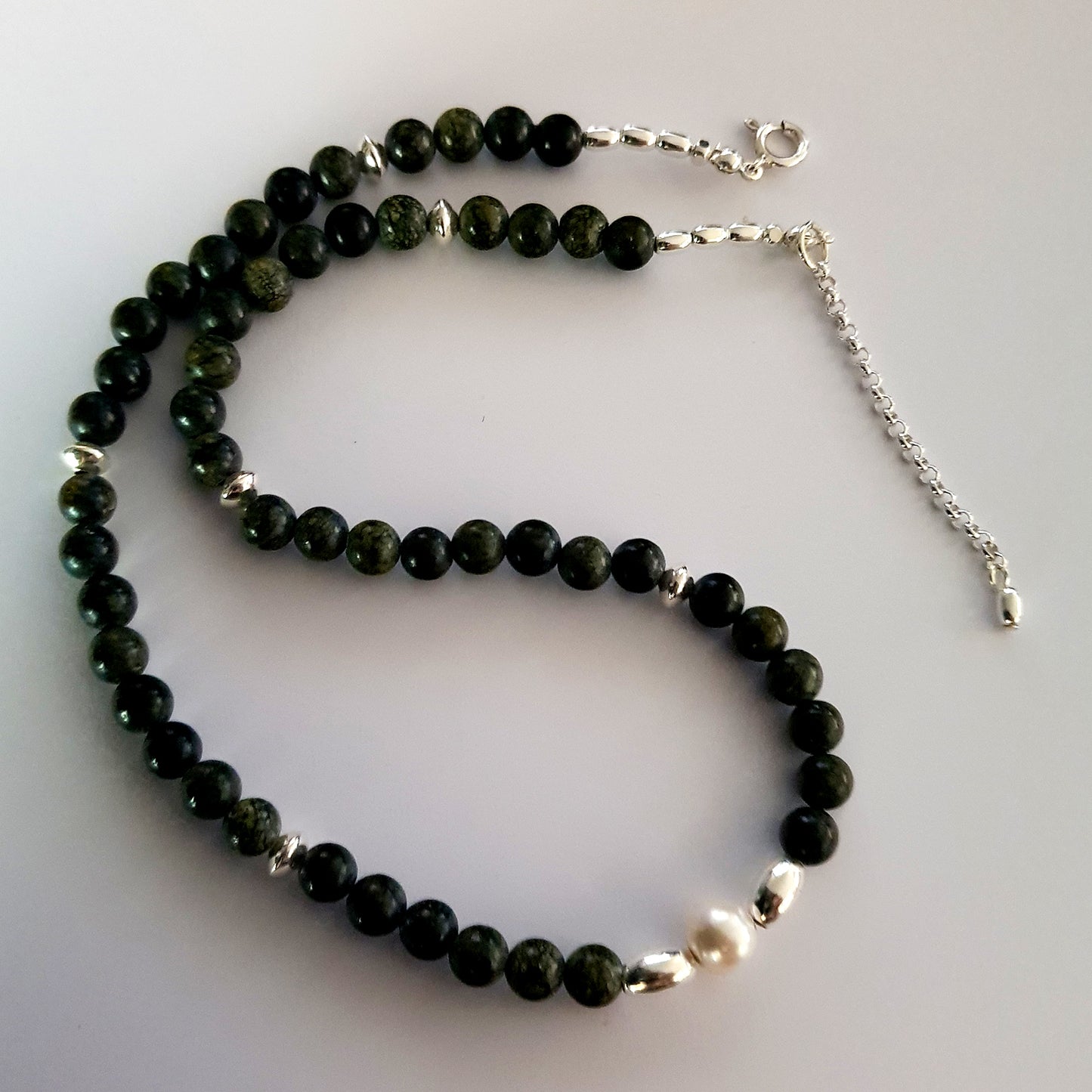 Necklace with green beads and a pearl with Sterling Silver Beads on a white background