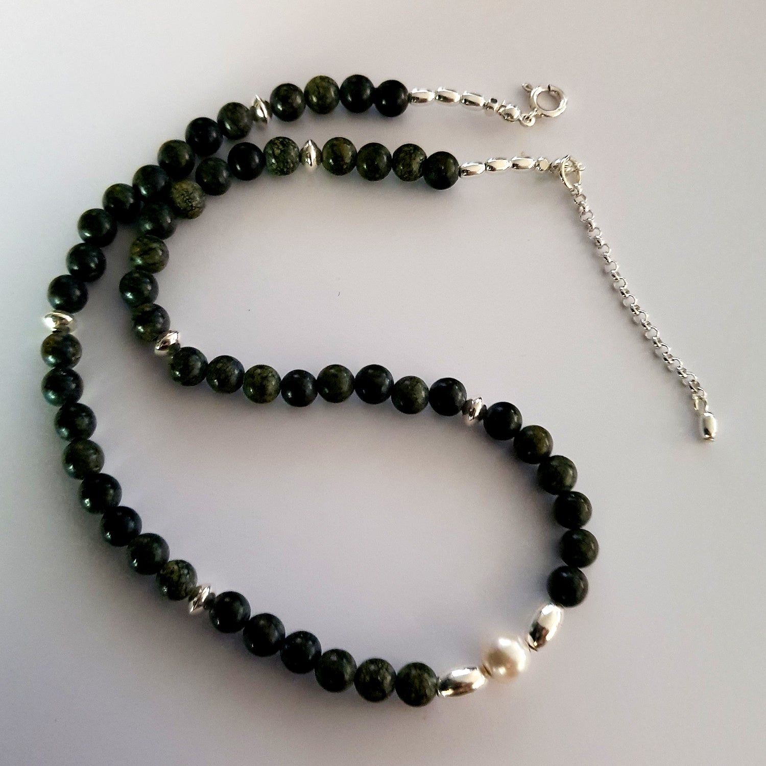 Necklace with green beads and a pearl with Sterling Silver Beads on a white background