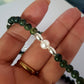 Hand holding necklace with pearl focal
