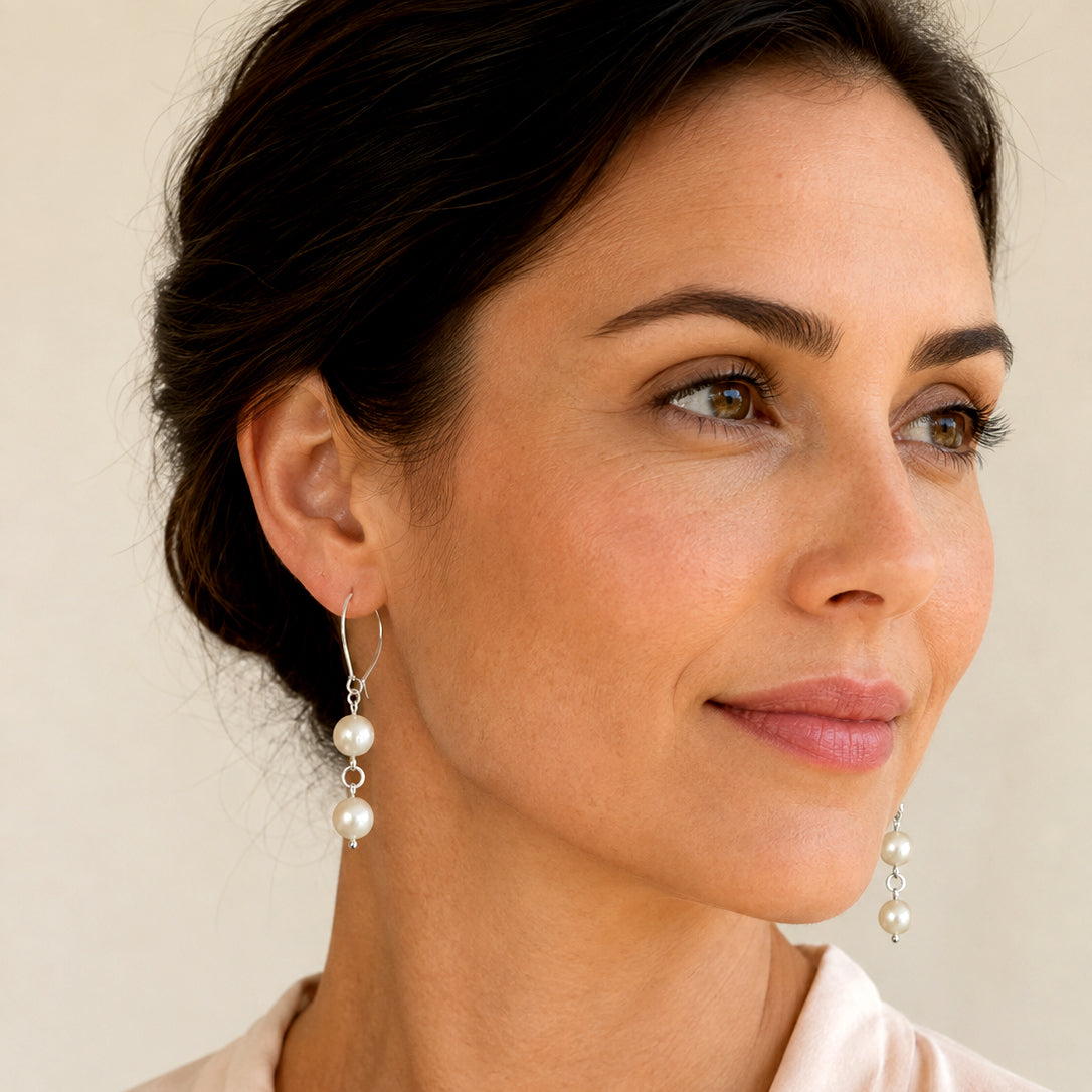 Model wearing handmade pearl drop earrings with sterling silver kidney hooks, showing both earrings – FKJ-209E by Kalitheo