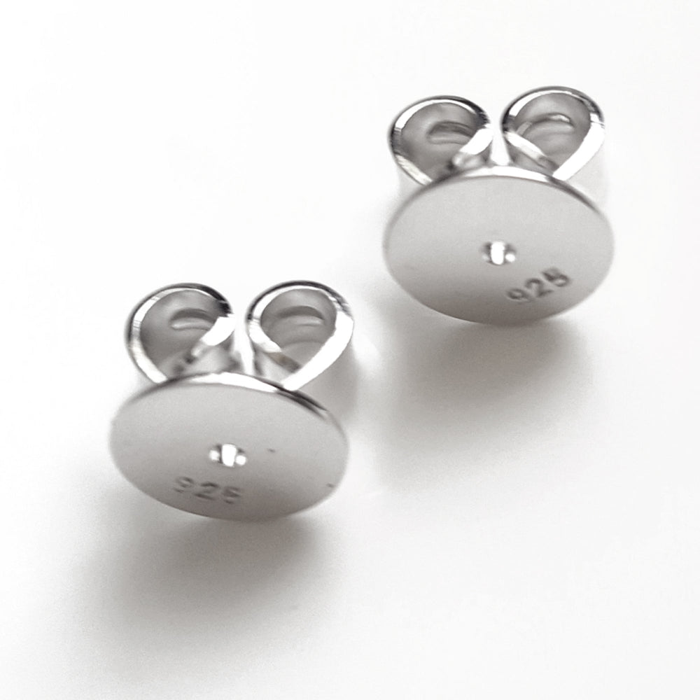 Pair of sterling silver disc butterfly earring backs with a white background.
