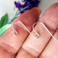 A pair of silver hooks on a hand blurred background