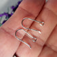 close up of a pair of open kidney hooks on a  hand blurred background