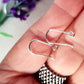pair of open kidney hooks on a hand blurred background