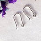 a pair of open kidney hooks on a white background purple flower in the top corner.