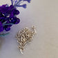 a bunch of sterling silver soldered eye pins on a white background. purple flower corner.