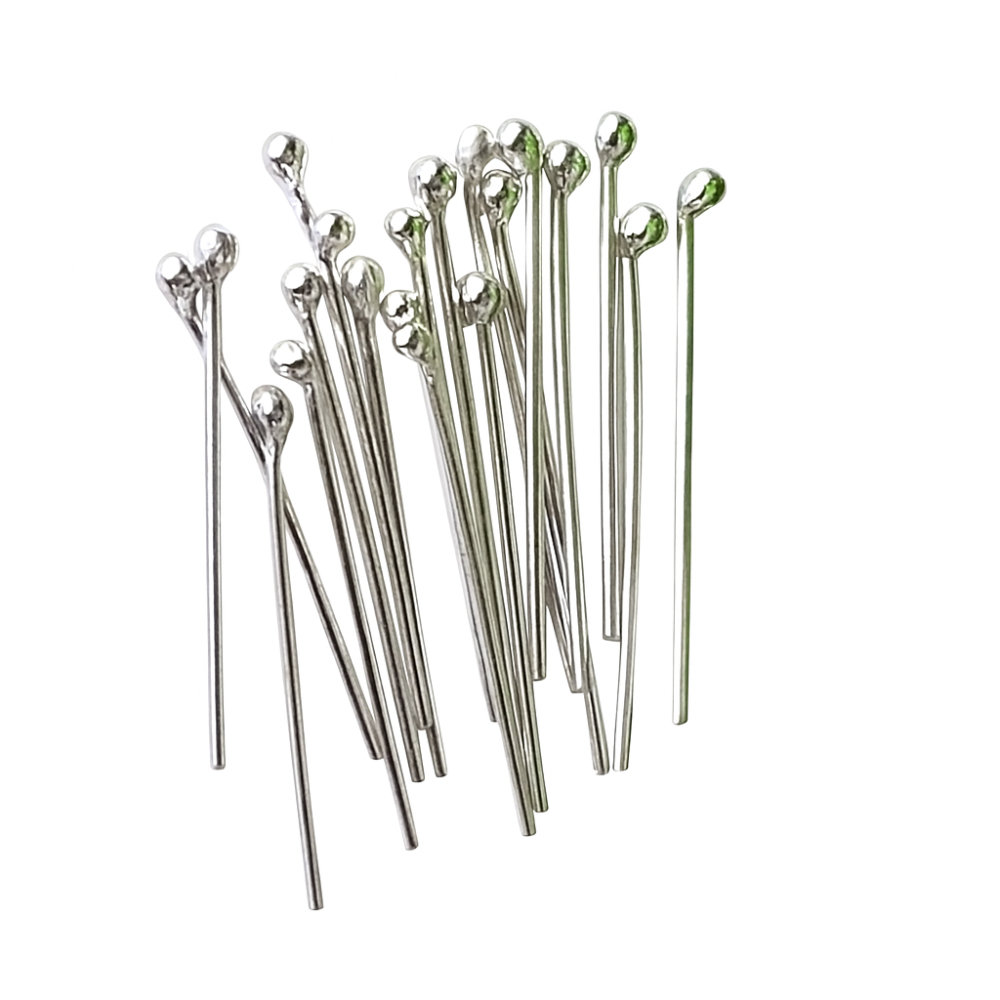 Set of silver headpins with balled tips on a white background