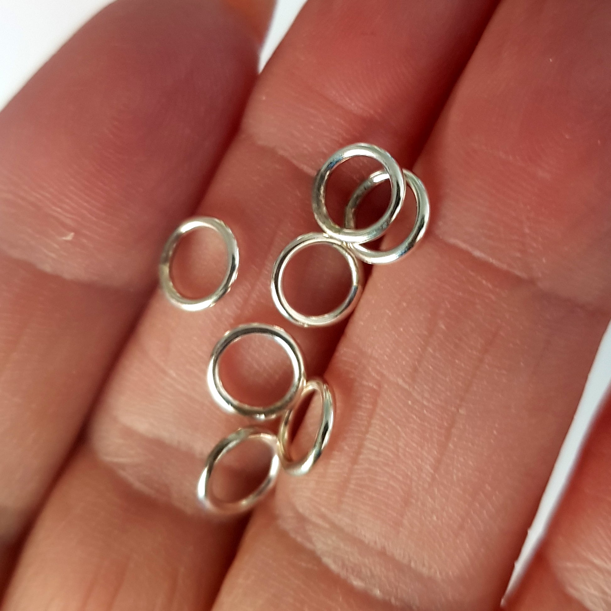 Silver ring-shaped jewelry pieces on a hand