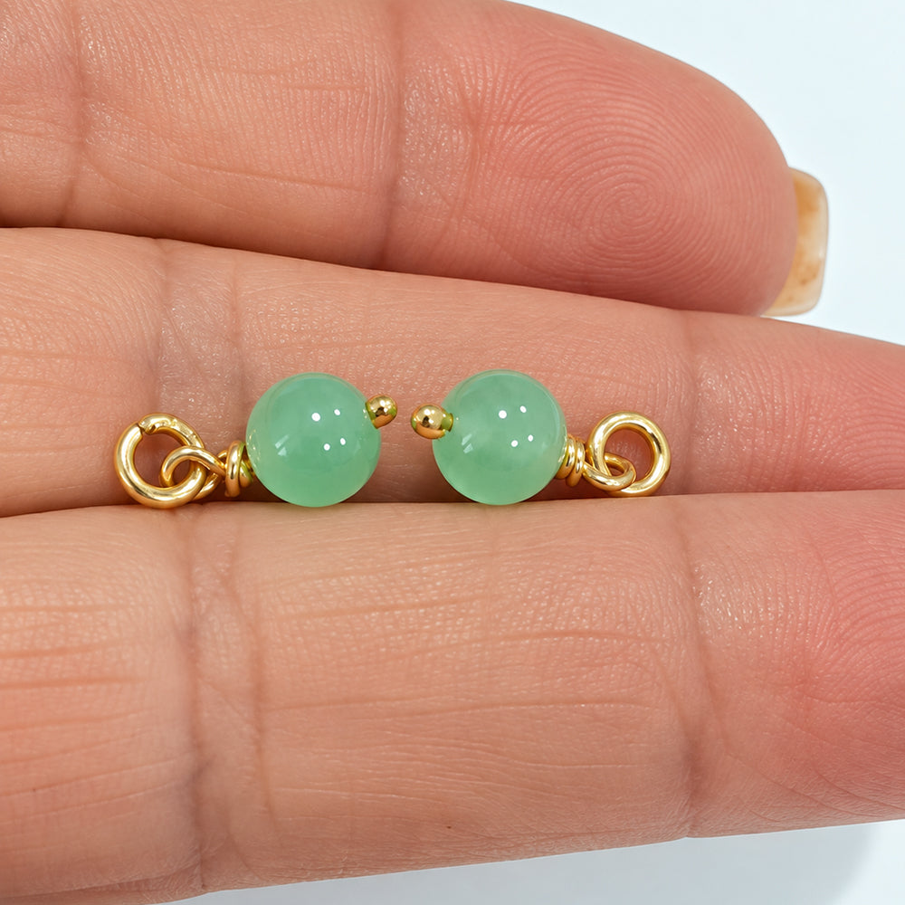 Pair of handmade 6.5 mm jade bead drop dangles with gold-coloured wire and open jump rings held on fingers, SKU DBD-Jade-1pair