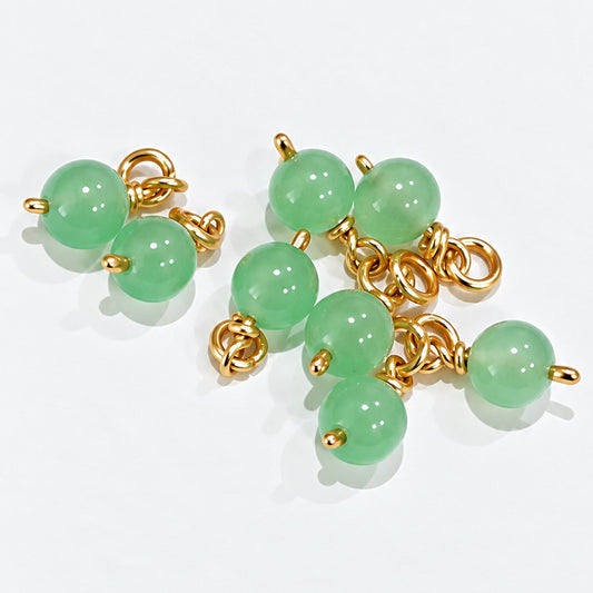 Two handmade jade bead drop dangles attached to a gold-coloured hoop beside a clustered jade bead design