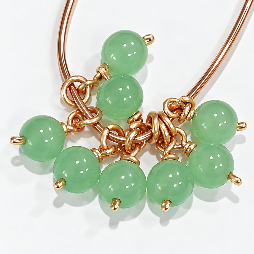 Loose pairs of handmade 6.5 mm green jade bead drop dangles with open jump rings on a white background