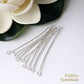 Silver eye pins on a white surface with a flower in the background, featuring the brand 'Kalitheo Handmade'.