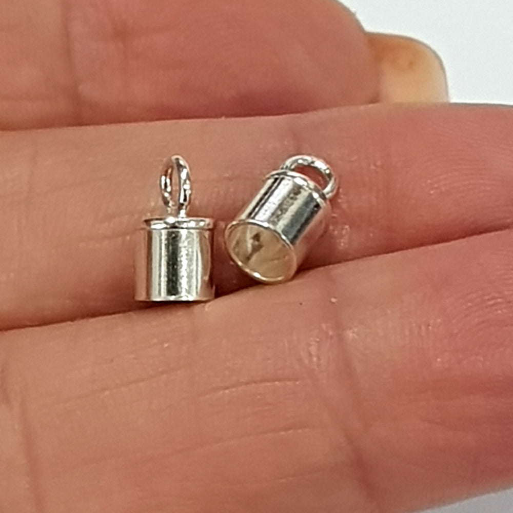 Two matching sterling silver barrel tube end caps side by side on a white background, open end facing outward with loop bails visible