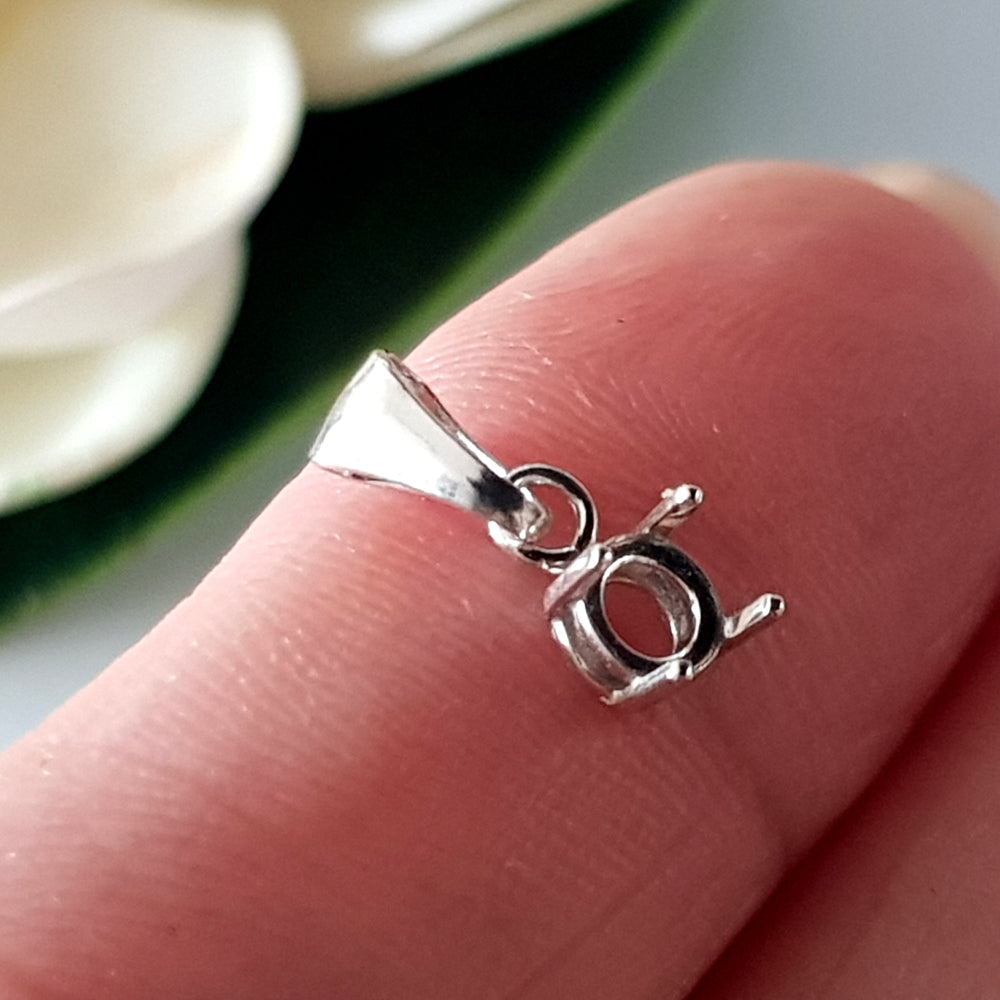 A sterling Silver pendant drop basket claw setting on a finger