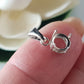 sterling silver 925 basket claw setting on a finger blurred background