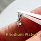 Silver pendant on a finger with 'Rhodium Plated' text