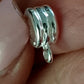 Sterling Silver Donut Bail between fingers.