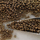 close up antique bronze beads with a bead scoop