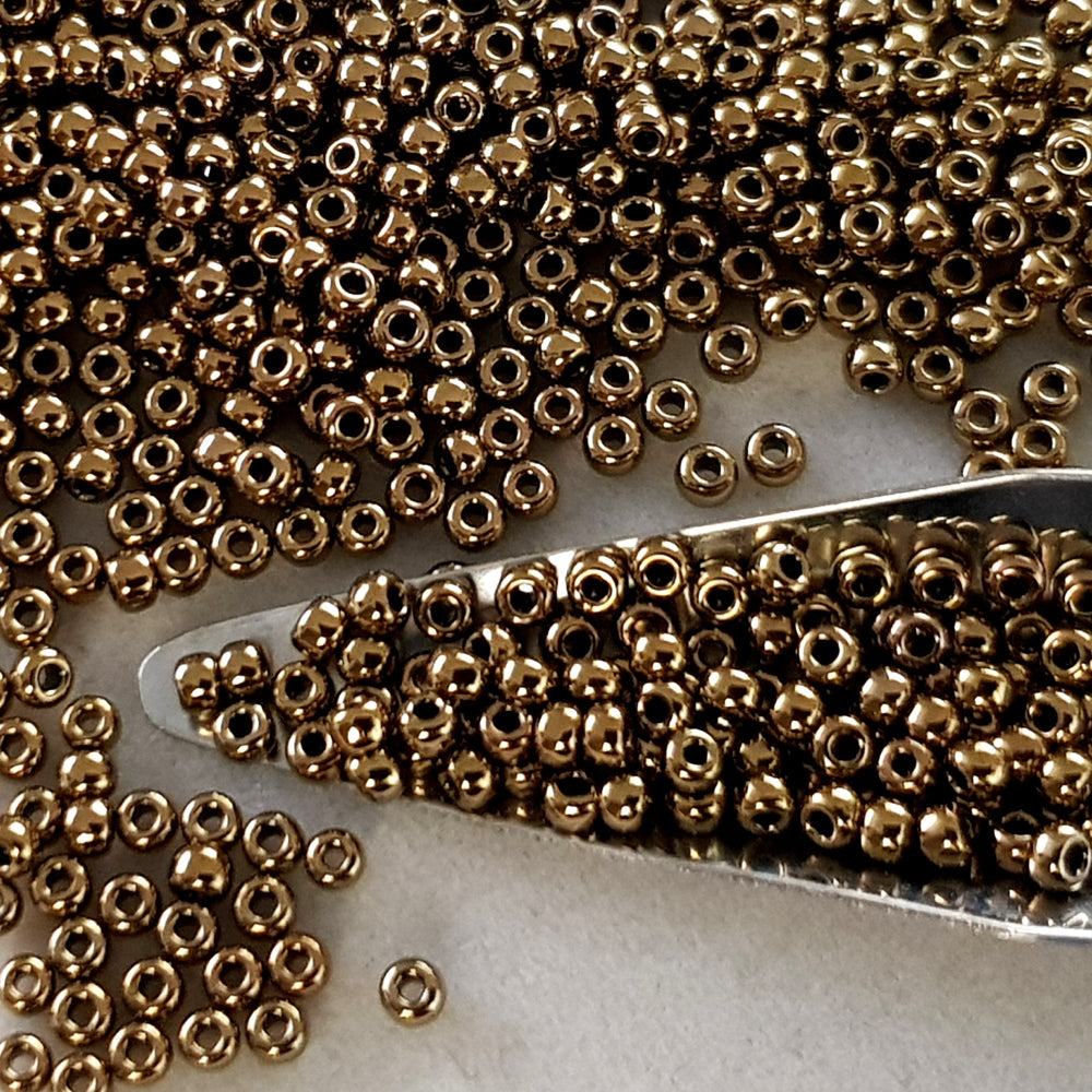 close up antique bronze beads with a bead scoop
