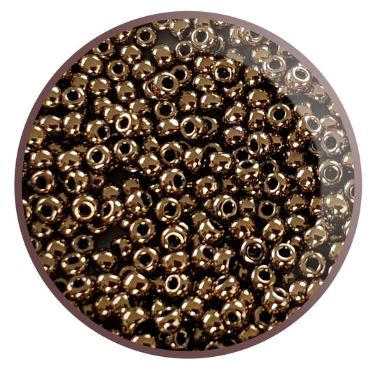 A round, antique bronze opaque Toho seed bead with a permanent finish.