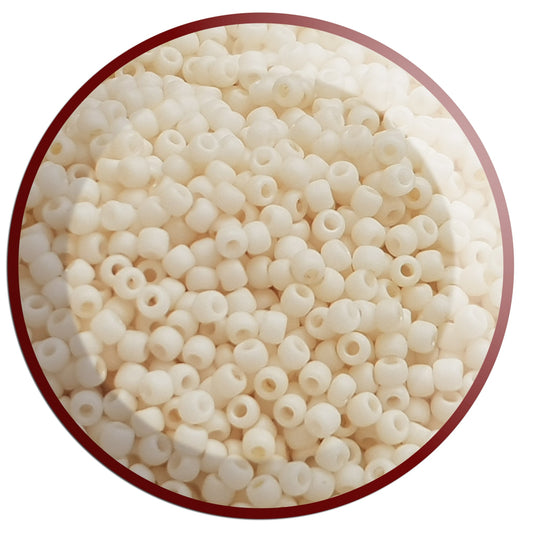 A close-up view of egg shell frosted opaque pastel round Toho seed in beads. circle with white bakcground.