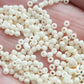 Close up egg shell beads on a hand.
