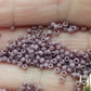 Close up lavender frosted beads on a hand