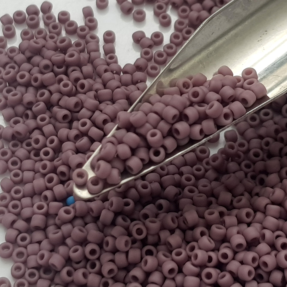 close up lavender beads on a bead scoop.