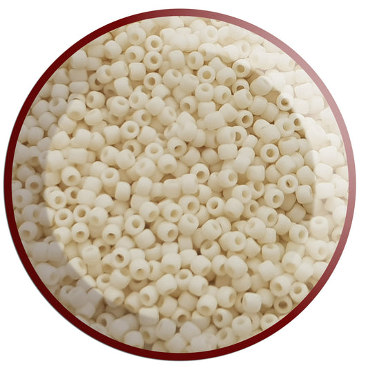 A close-up view of light beige frosted opaque round Toho seed beads. 11/0 circle white background