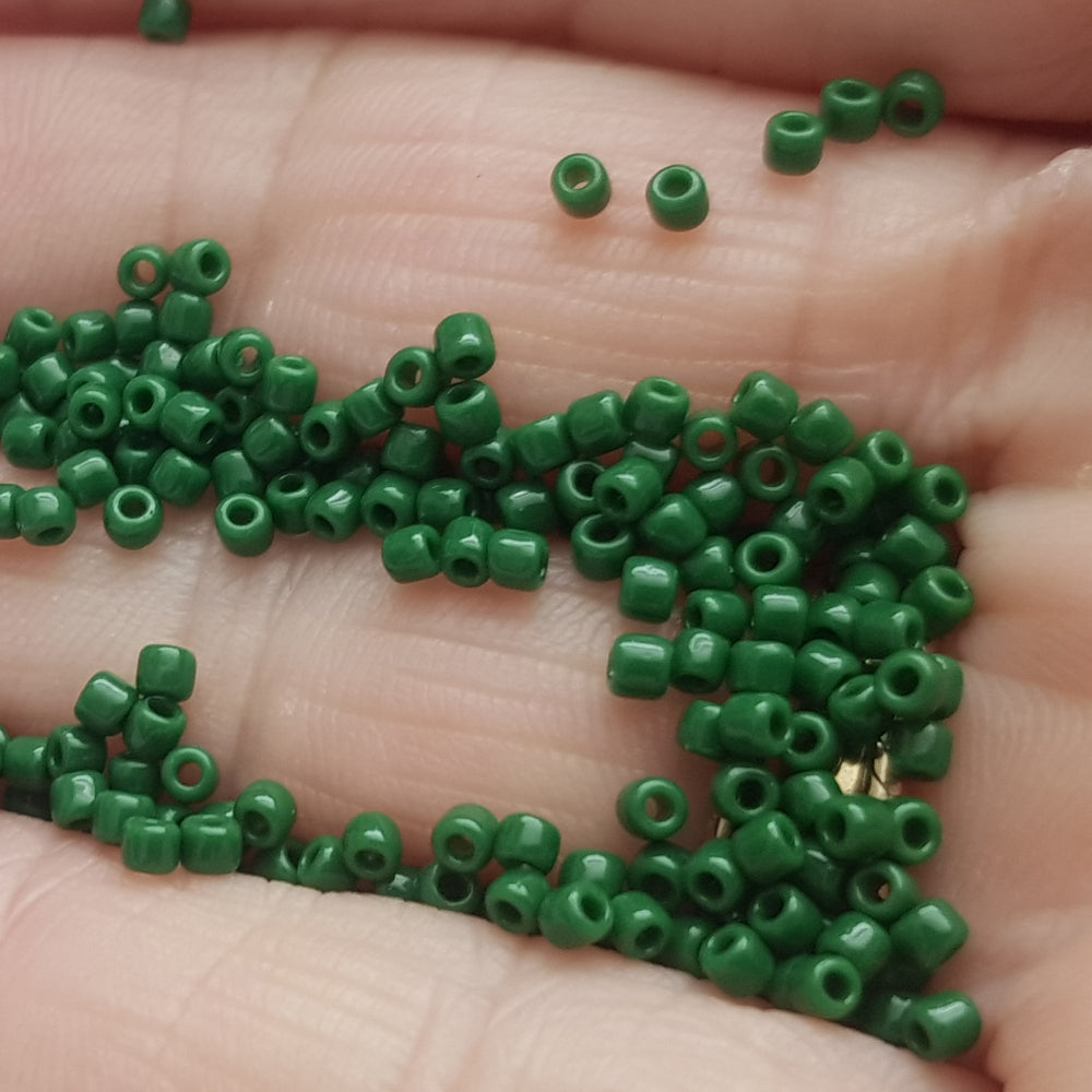 11/0 Toho Seed beads in pine green opaque TR-47H on a hand.