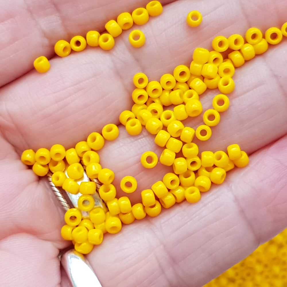 close up yellow beads on a hand.